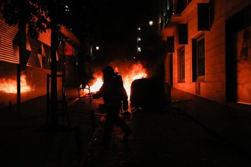 Bomberos de Barcelona tratan de sofocar las llamas de un contenedor.