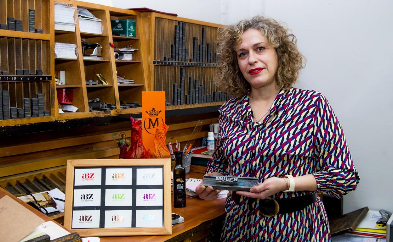 Eva Gil compone la palabra 'mujer' con tipos de imprenta. 