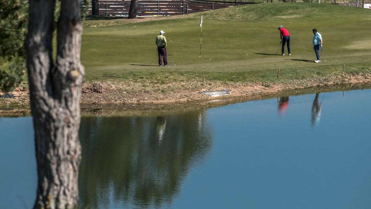 Los integrantes de un partido, acabando un hoyo junto al lago. 