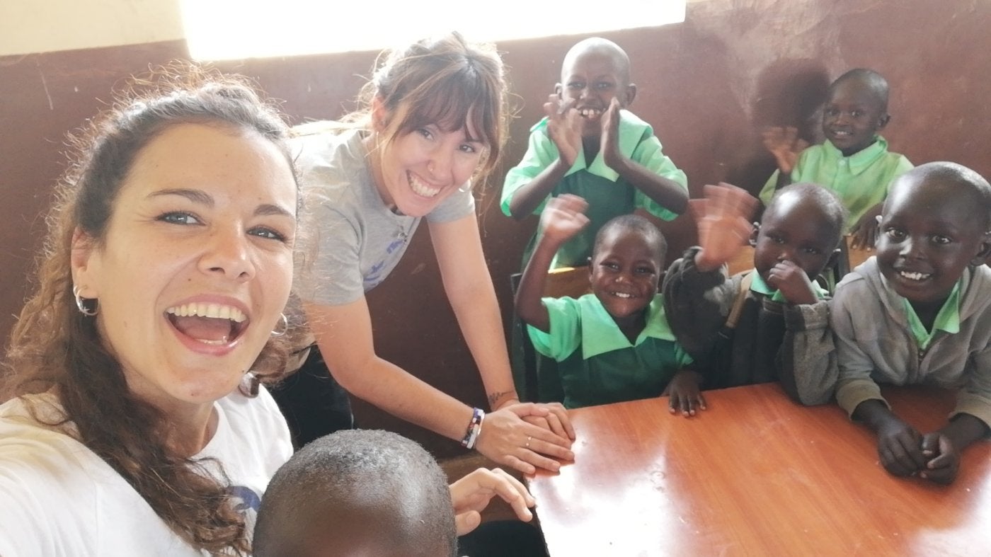 Sandra Blázquez y María Fábregas, con niños de su escuela. 