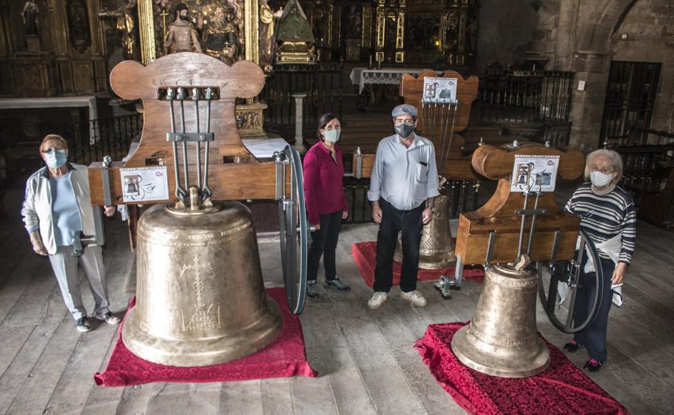 Entre campanas. Varios vecinos de Grañón posan junto a las piezas restauradas, que hasta el lunes 31 pueden visitarse en la iglesia. 