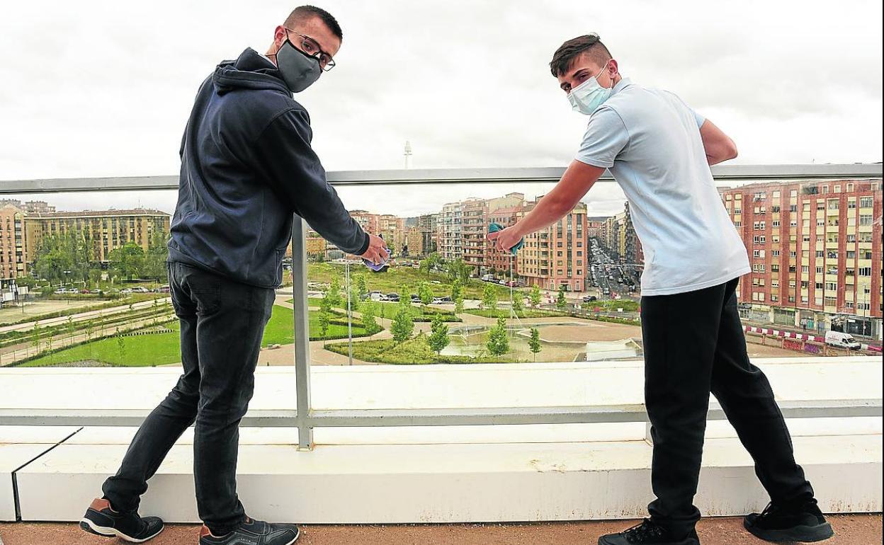 Eduardo Pastor Martin y Álex Alonso Heras, este viernes, bayeta en mano en el mirador que limpiaron. 