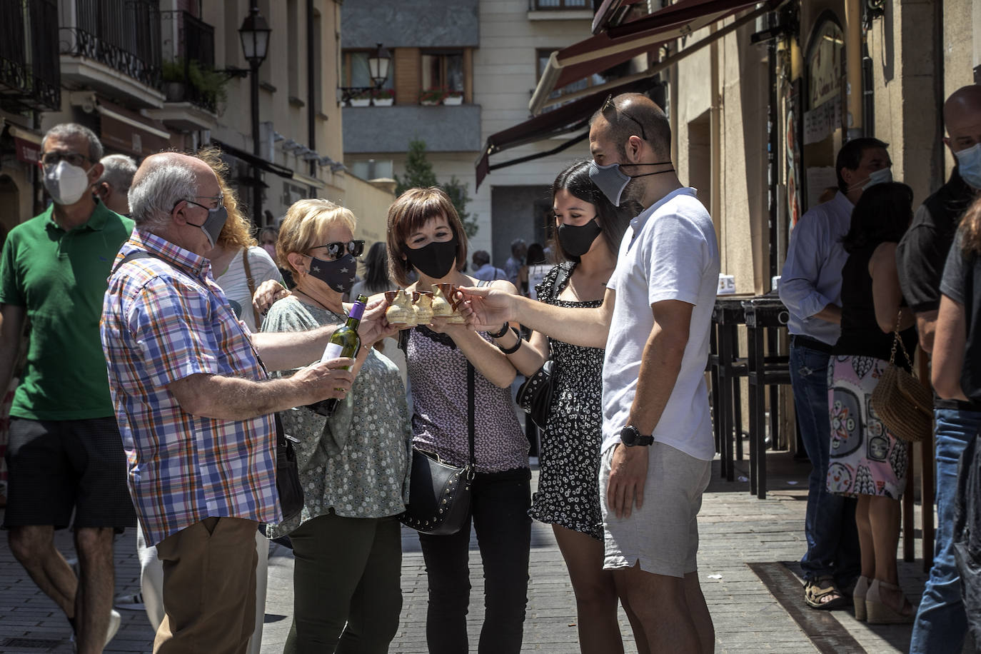 Una familia brinda con el típico jarrito de San Bernabé, en la calle Laurel. 