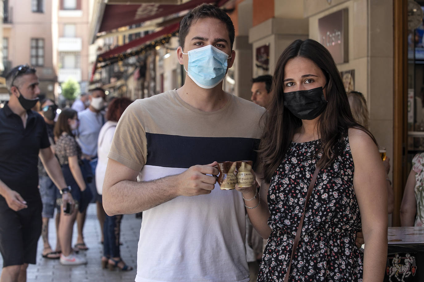 Dos jóvenes brindan con el típico jarrito de San Bernabé, en la calle Laurel. 
