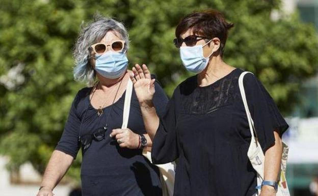 Dos mujeres pasean con la mascarilla.