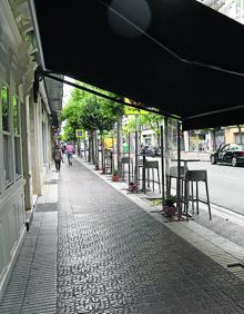 Imagen secundaria 2 - Arriba, la plaza del Mercado, donde los bares han podido aumentar la superficie de sus veladores, está dando que hablar dada su ocupación. Abajo, terraza en Pérez Galdós ganada al aparcamiento en zona azul y solución para que avenida de Portugal siga con las mesas altas. 