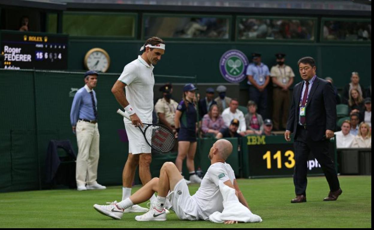 Federer habla con Mannarino tras la lesión de este último. 