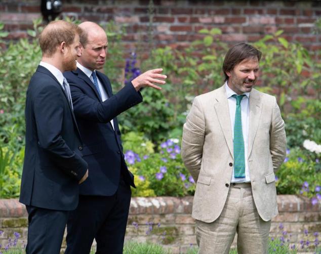 El príncipe y heredero William, y su hermano Harry, conversan con el diseñador de los jardines que albergan la estatua en recuerdo de su madre. La imagen muestra cercanía tras varios meses de distanciamientos entre los hijos de Lady Di.