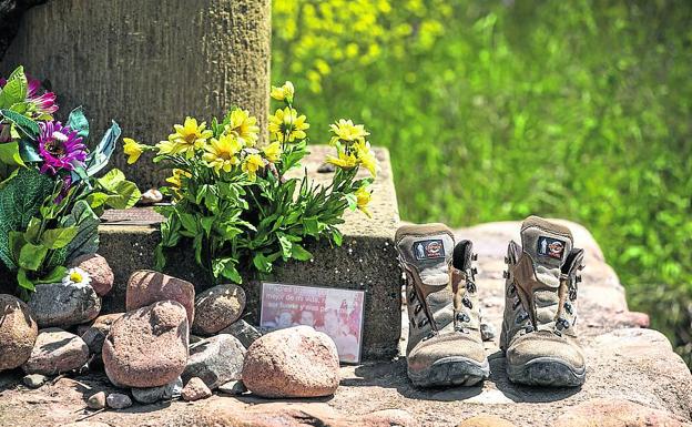 Flores, piedras, una foto y unas botas como ofrenda en uno de los cruceros que jalonan el itinerario. 