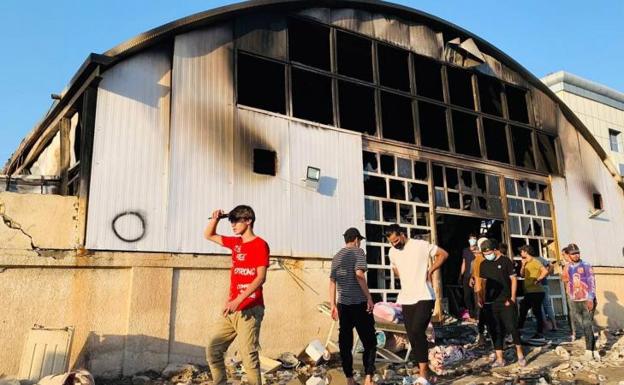 Varios curiosos inspeccionan el lugar tras el incendio declarado en un hospital de la ciudad de Nasiriy 