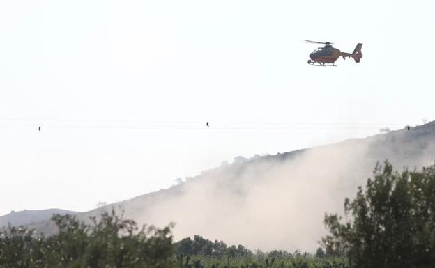 Un helicóptero, trabajando en la zona del incendio, esta mañana