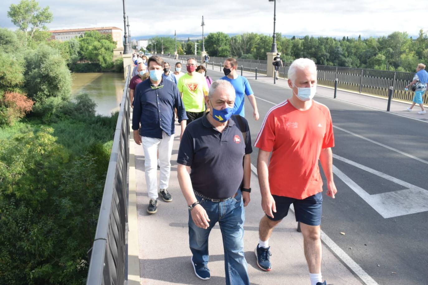 Imagen principal - Arriba, salida desde el Puente de Piedra y, abajo, unas peregrinas alemanas que se han sumado al grupo entran en la iglesia de Santiago, momento en el que Pablo Hermoso de Mendoza cruza el Arco del Revellín. 