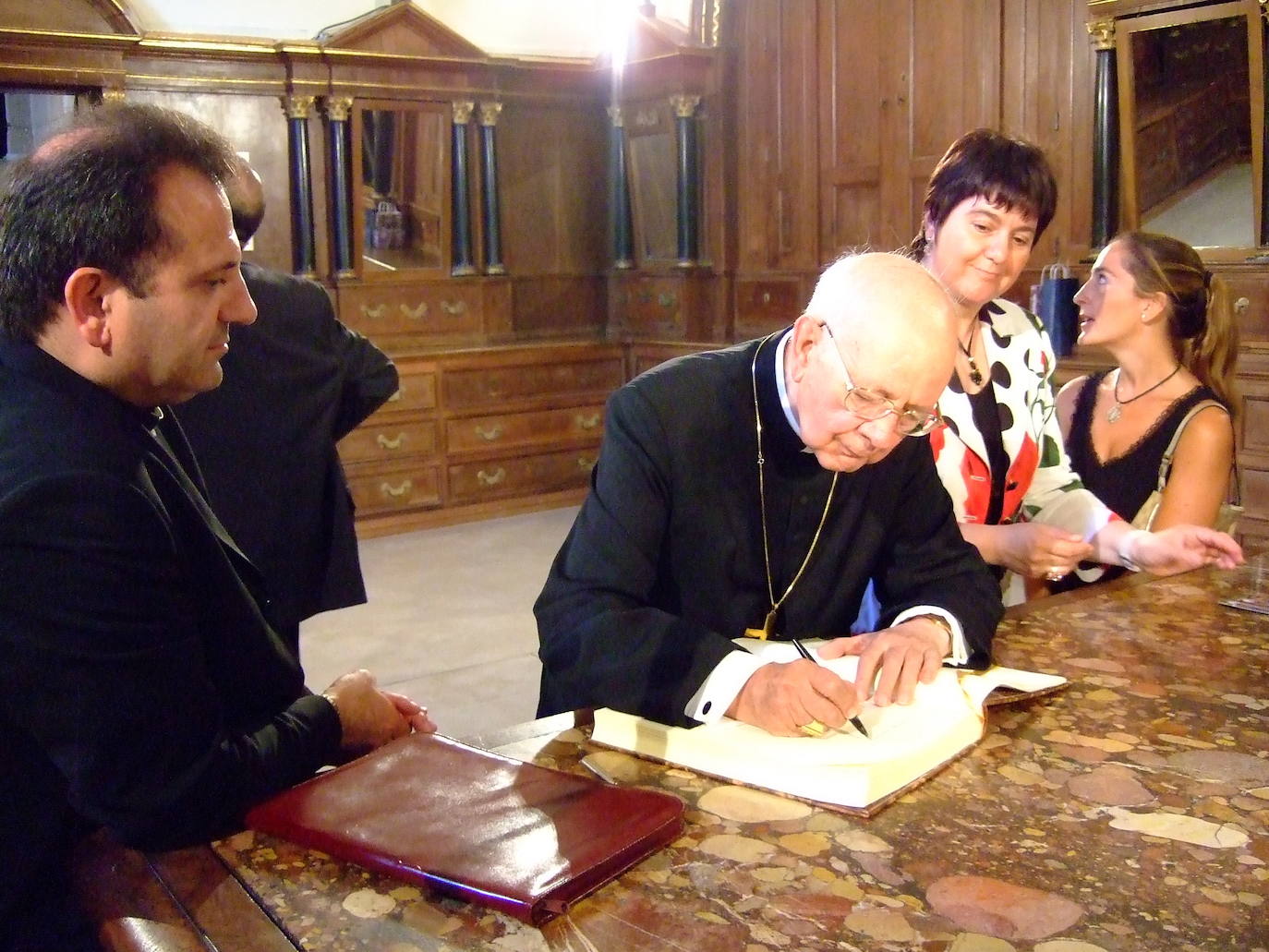 El cardenal firma el libro de honor en la catedral calceatense.