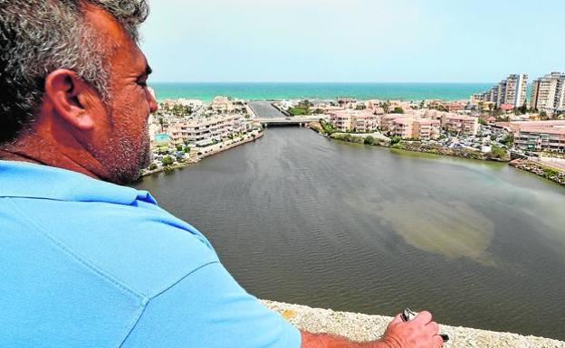 Un vecino observa desde lo alto el canal de Marchamalo, en La Manga del Mar Menor 