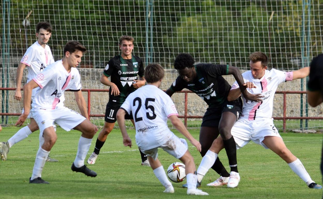 Varios jugadores del Racing Rioja luchan por robarle el cuero a Ibra. 