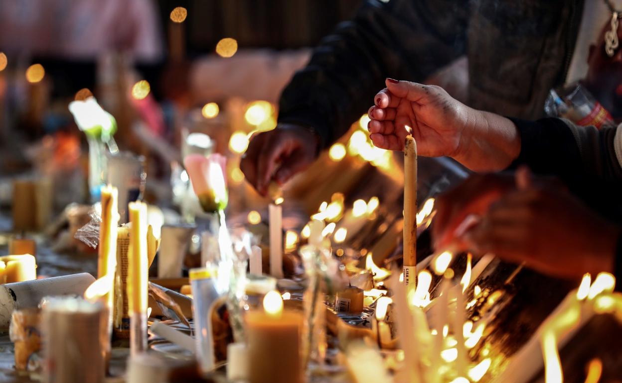 Fieles, orando y poniendo velas en una iglesia. 