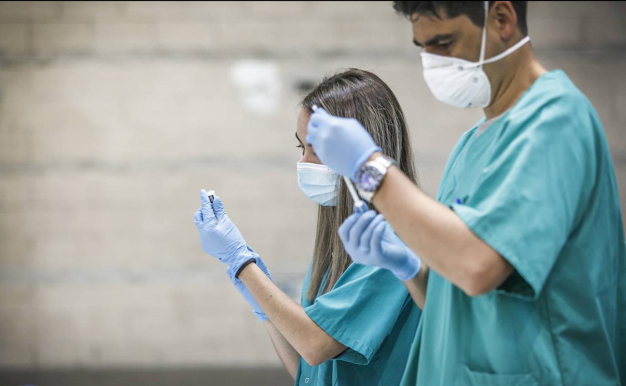 Dos profesionales sanitarios preparan vacunas en Villamediana de Iregua. 