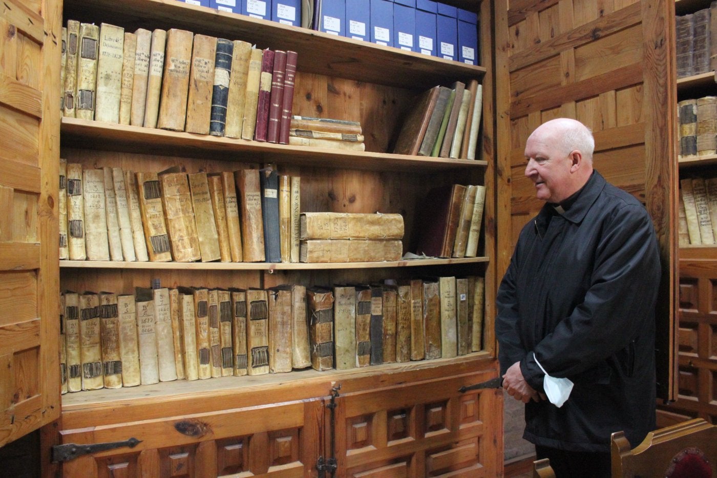 El sacerdote Carlos Esteban Hernando observa el armario en el que las parroquias han reunido su archivo histórico. 