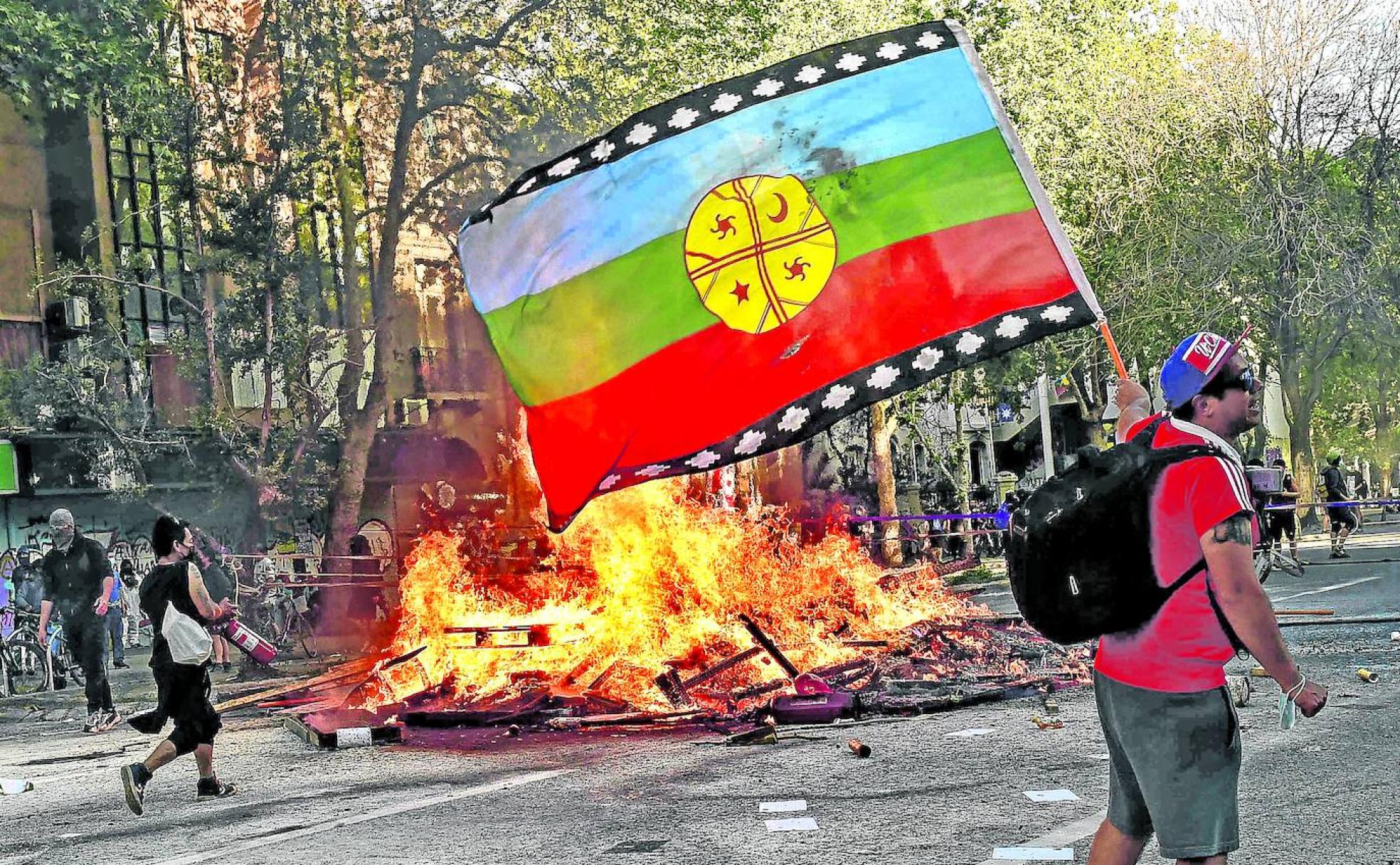 Un manifestante enarbola la bandera mapuche en las protestas llevadas a cabo en el corazón de Santiago.