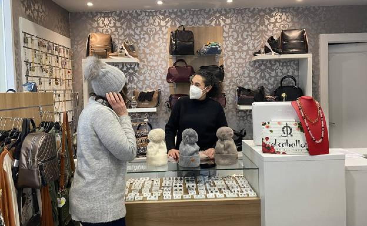 Una clienta se prueba gorros en la tienda Estilo Moda y Complementos. 