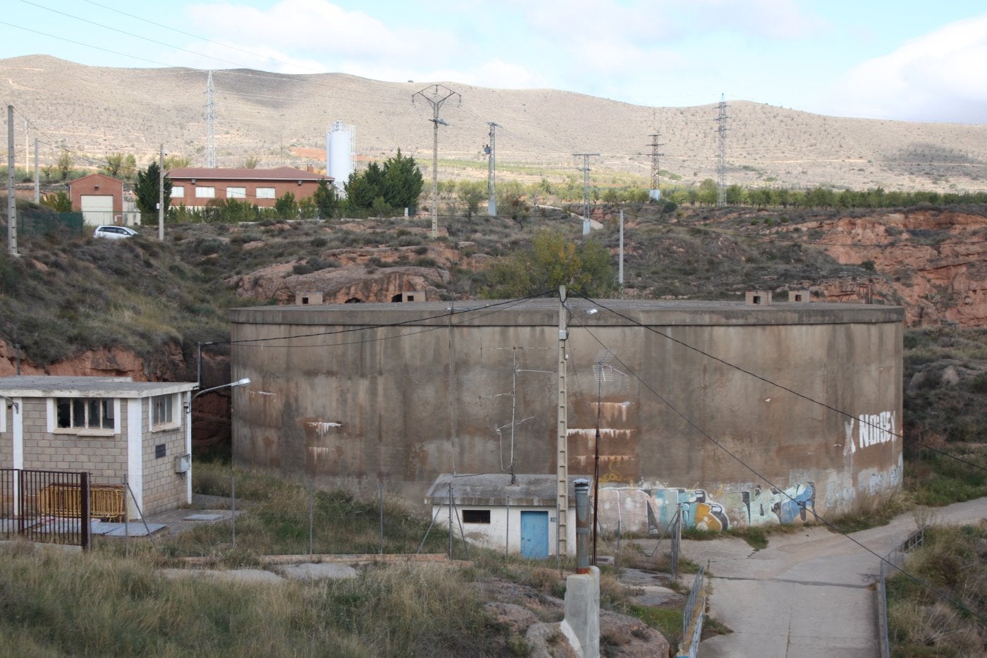 Imagen del actual depósito de aguas, que tiene más de 40 años de servicio, con la estación depuradora al fondo. 