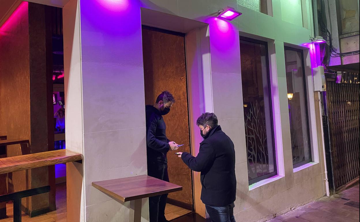 David Ijalba solicita el certificado a un cliente a las puertas del bar-discoteca 'Lio20', en la calle Arrabal.