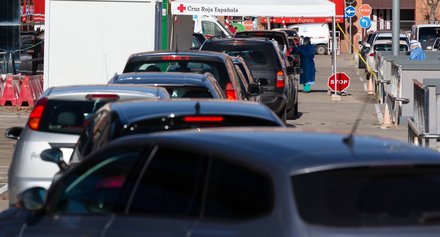 Hileras de coches, en vísperas de Nochevieja ante el punto fijo de realización de pruebas diagnósticas PCR, en el parking del CIBIR. 