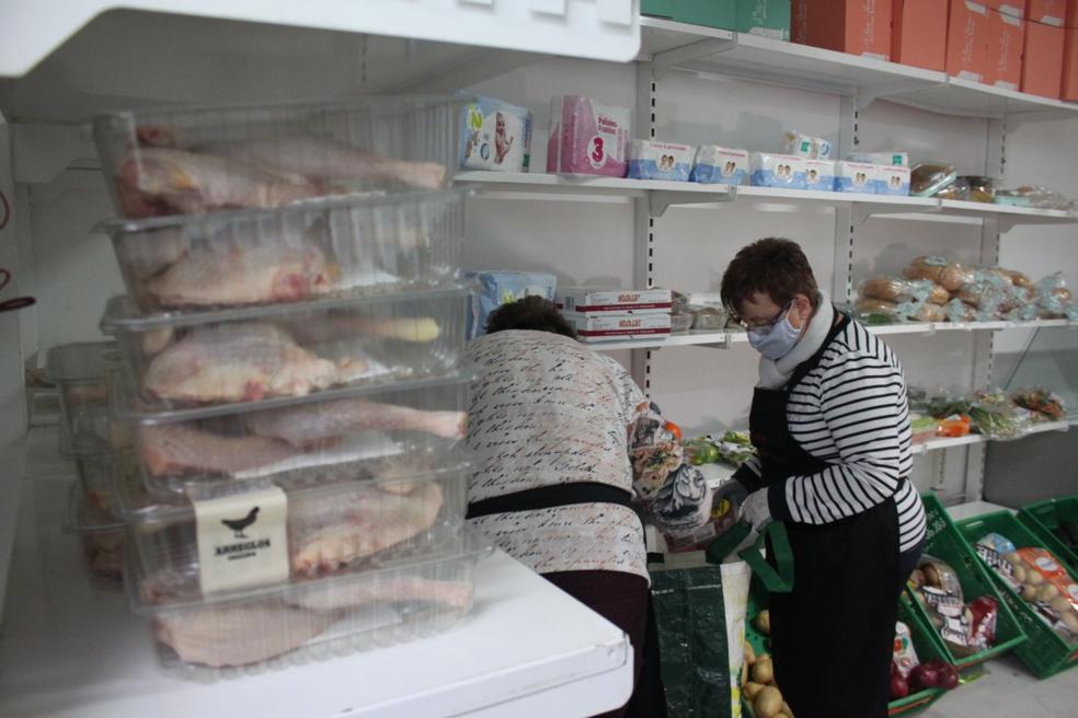 Los voluntarios de Cáritas organizan en las estanterías lo donado por Mercadona. 