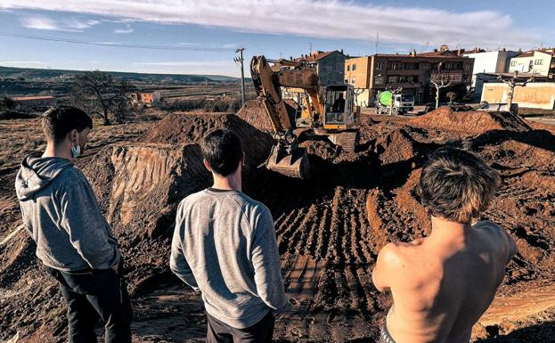 Tres jóvenes de Entrena observan las obras en el 'pump track'. 