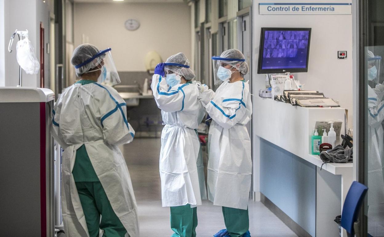 Profesionales sanitarias de la Unidad de Críticos del San Pedro se ayudan a ajustarse el EPI antes de acceder al box que ocupa un paciente ingresado por COVID. 