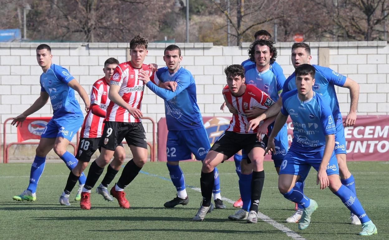 Jugadores de ambos equipos esperan el esférico. 