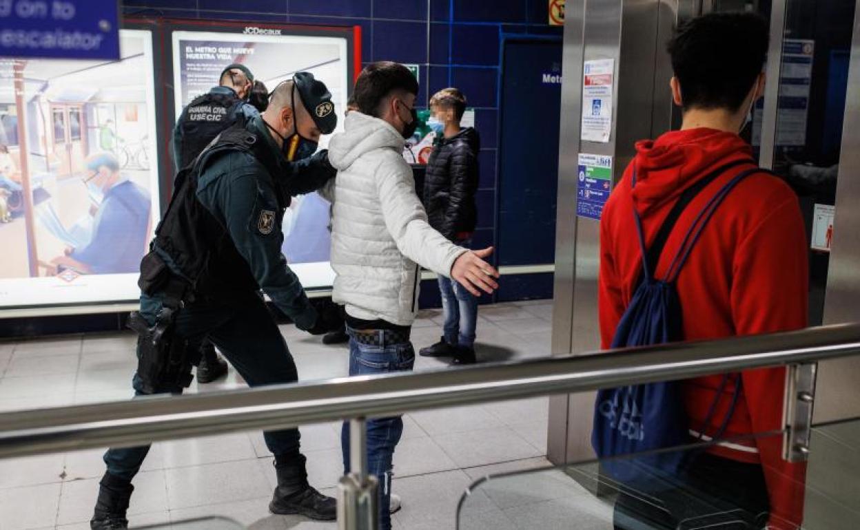 La Guardia Civil cachea a varios jóvenes en una estación de Metro de Madrid. 