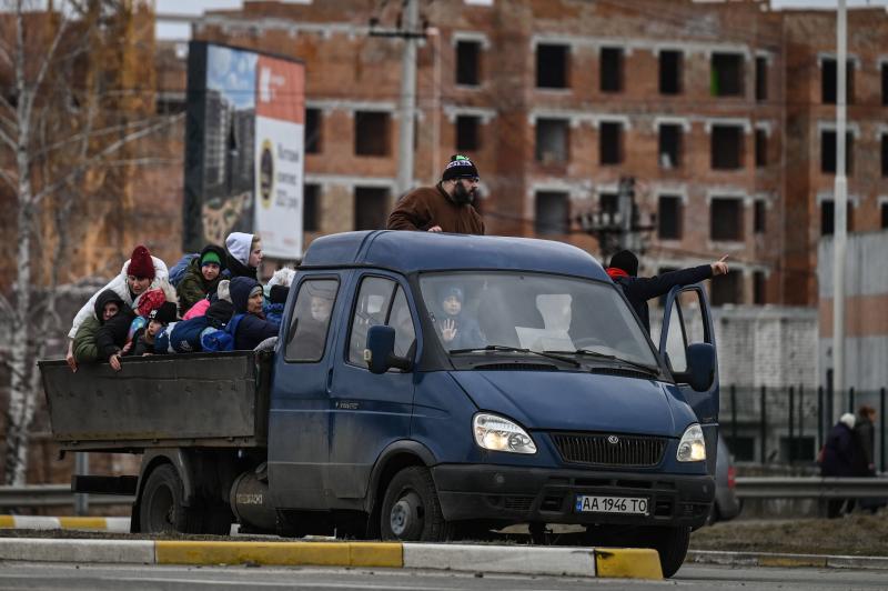 Varias personas se suben a un automóvil mientras evacuan la ciudad de Irpin.