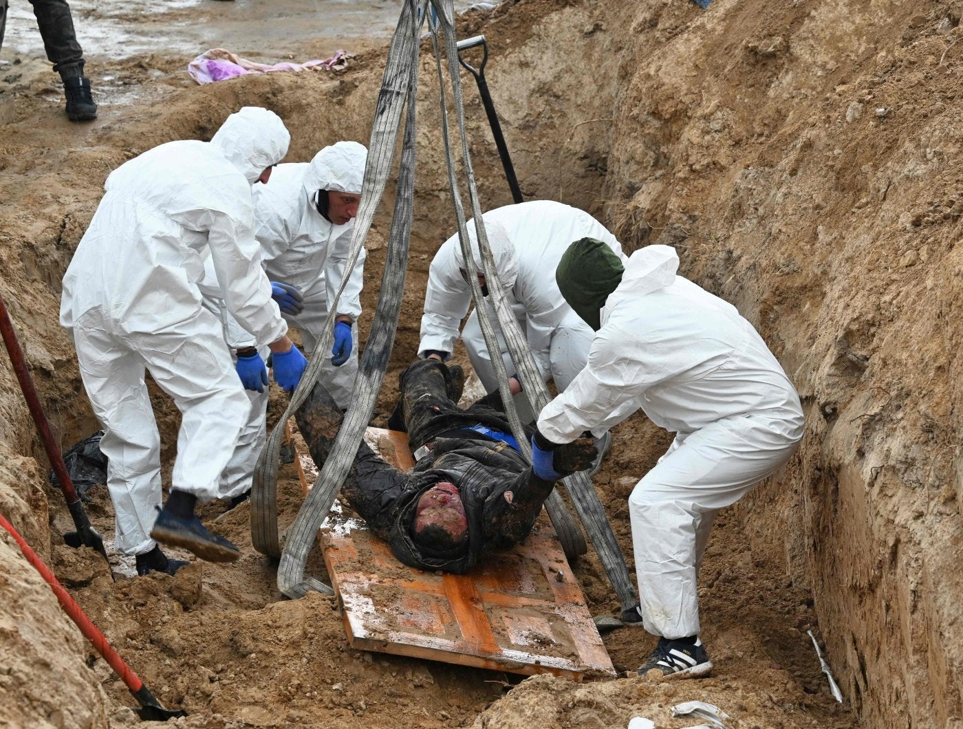 Investigadores ucranianos exhuman un cadáver en Bucha. 