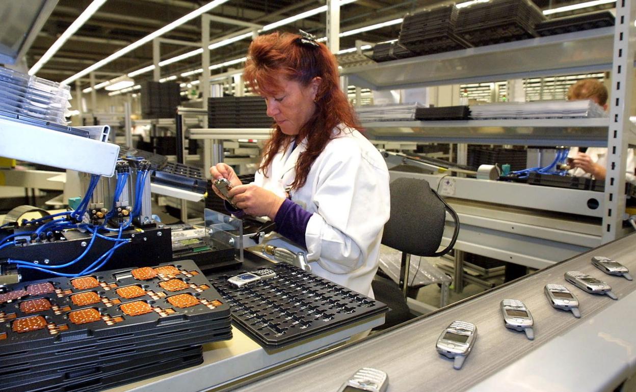 Una mujer, en la cadena de montaje de una una empresa tecnológica. 