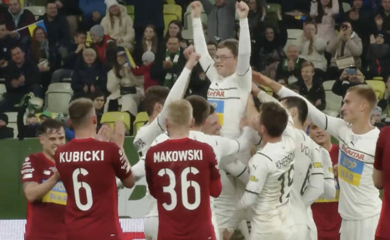 El niño ucraniano Dmytro Keda celebra su gol en un partido de jugadores profesionales en Polonia.