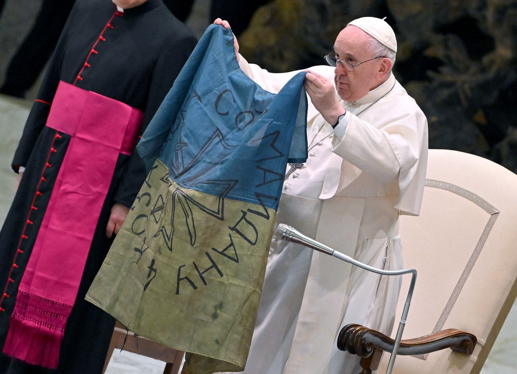 Francisco muestra una bandera de Ucrania enviada desde Bucha. 