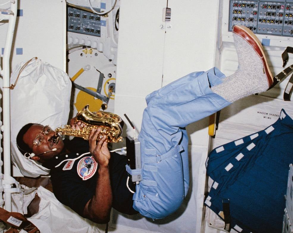 Imagen principal - Ronald A. McNair tocando el saxofón, el grupo AstroHawaii formado por cuatro astronautas que coincidieron en la ISS y Naoko Yamazaki, con un instrumento tradicional japonés. 