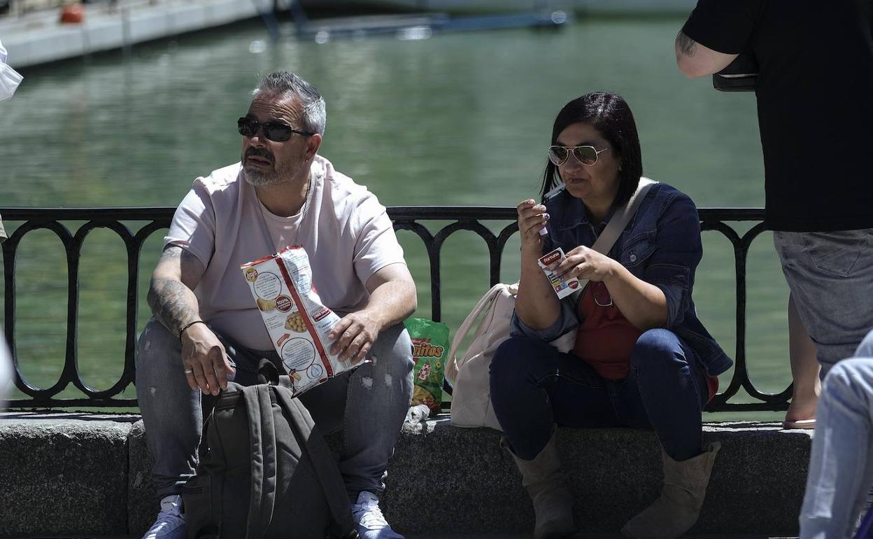 Dos personas fumando en el Parque del Retiro.