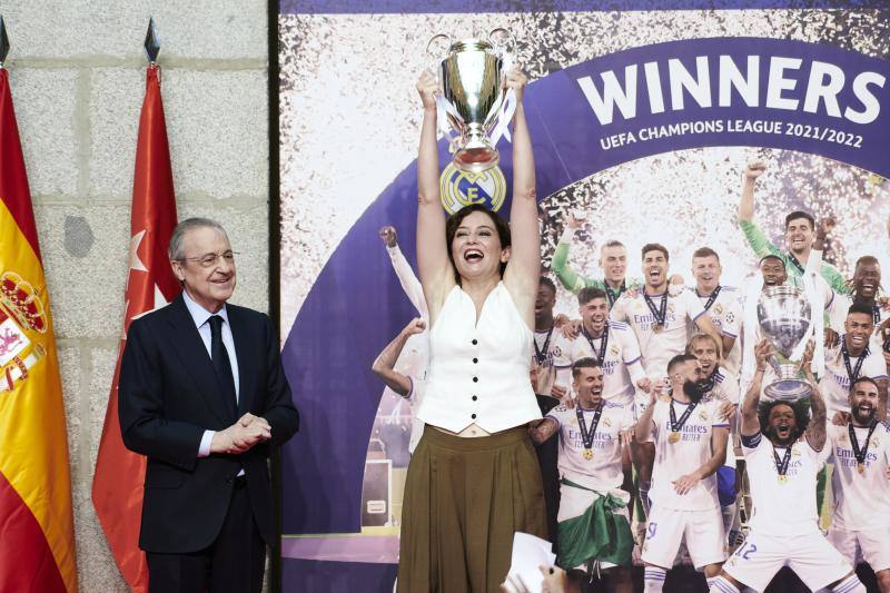 Isabel Díaz Ayuso levanta eufórica una réplica de la 'orejona' que le entregó Florentino Pérez durante la visita de la plantilla del Real Madrid a la sede de la Comunidad de Madrid.