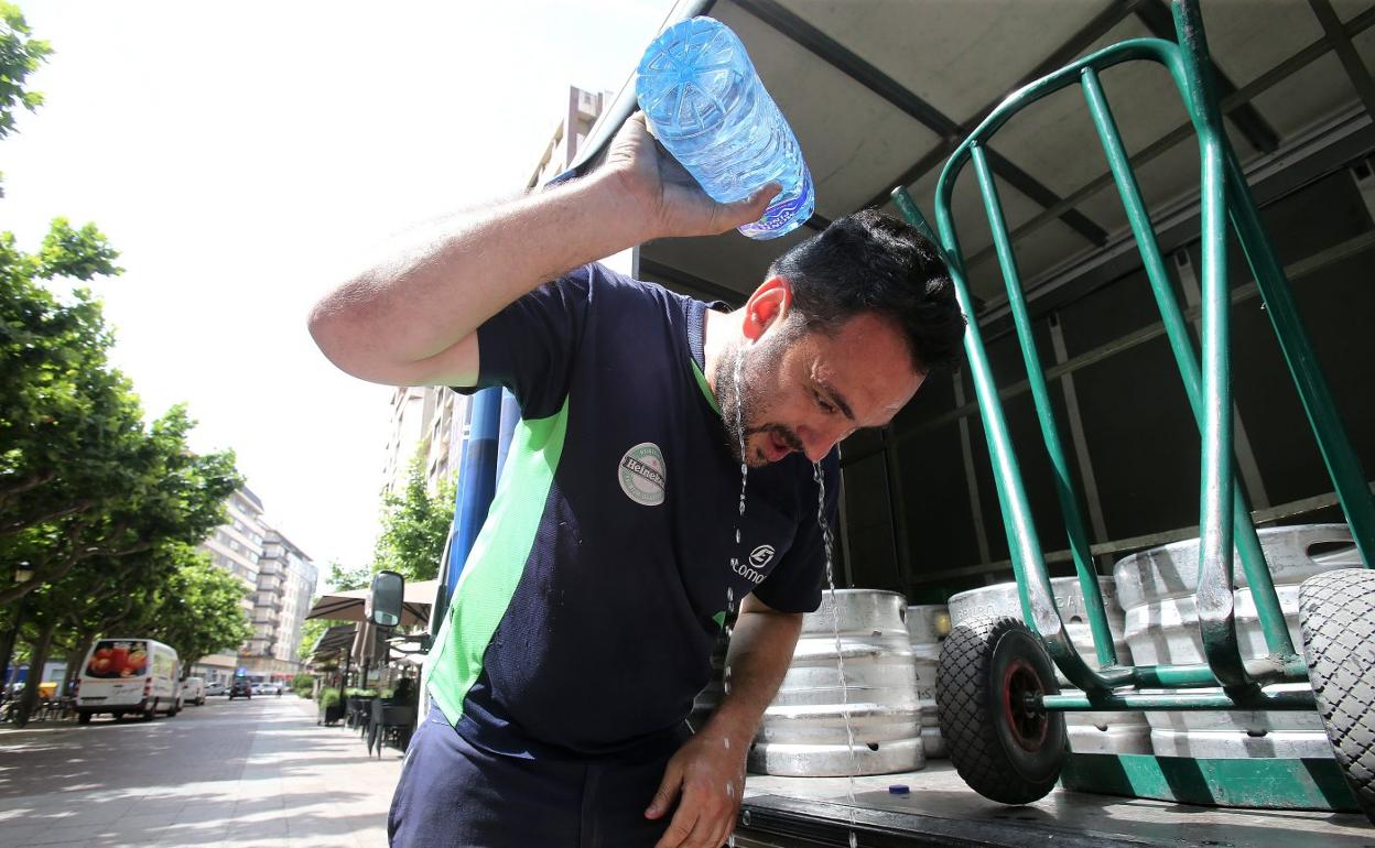 Un trabajador se refresca durante la pasada ola de calor. 