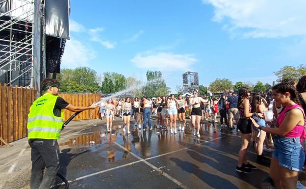 Agua a manguerazos, el remedio para soportar el calor a la espera de los conciertos. 