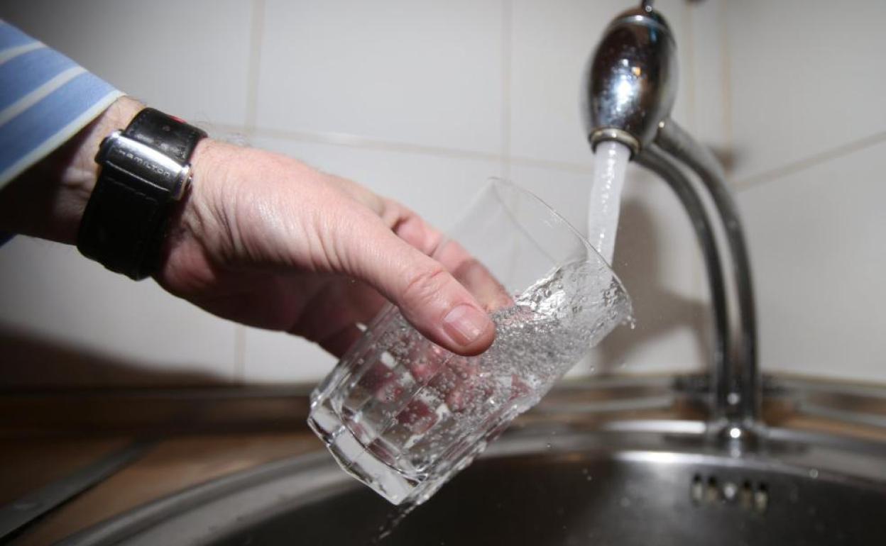 Un ciudadano llena un vaso con agua del grifo.