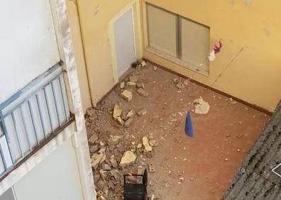 Imagen secundaria 1 - Los vecinos desalojados esperan en el exterior.; en el patio interior, lleno de cascotes, se encuentra aún el cadáver del fallecido