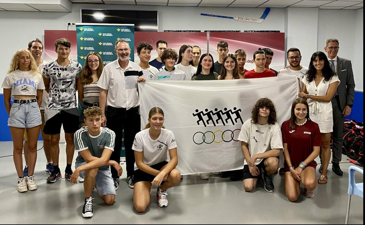 Los 18 atletas riojanos y sus entrenadores, junto al concejal de Deportes, Rubén Antoñanzas, y el responsable institucional de Caja Rural de Navarra, Ernesto Navarrete, posan con la bandera de los Juegos. 