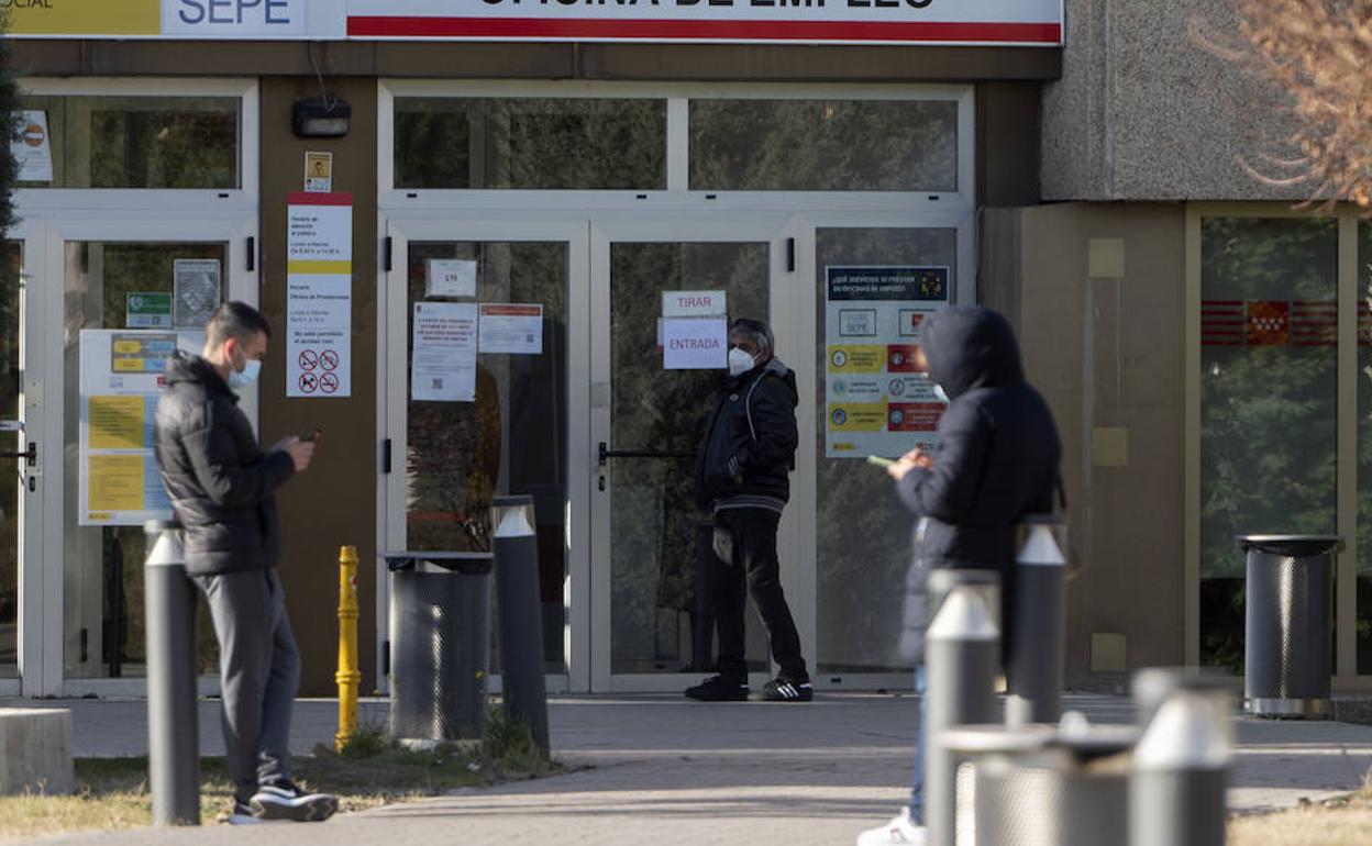 Varias personas hacen cola en una oficina de empleo. 