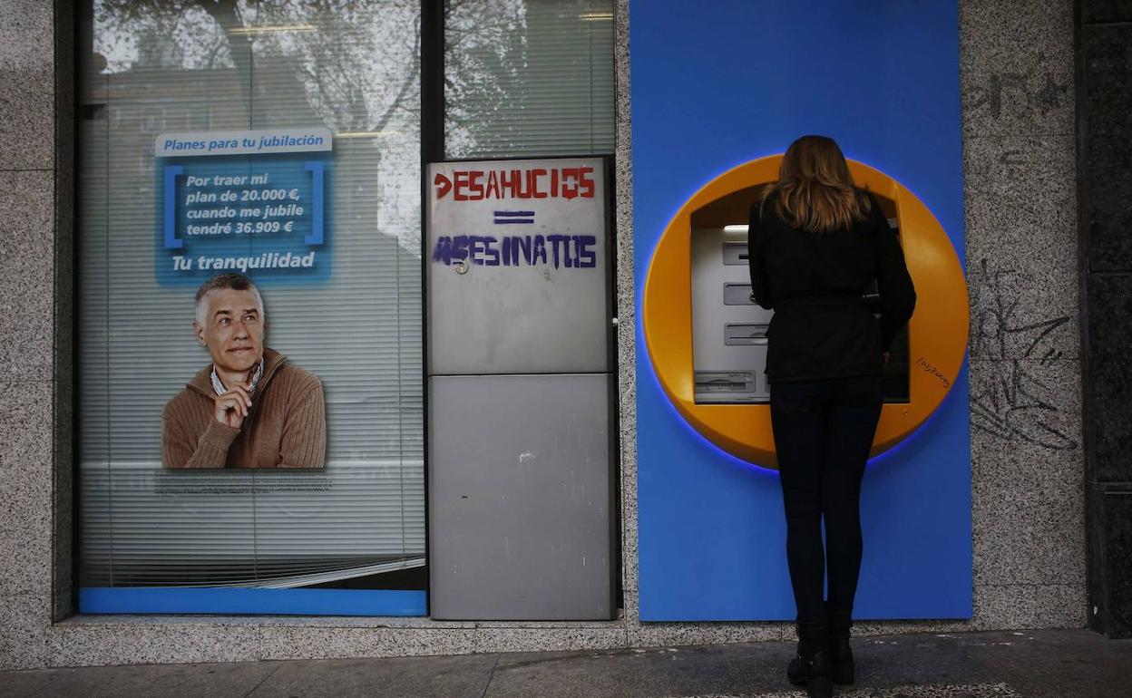 Una mujer saca dinero de un cajero en Madrid. 