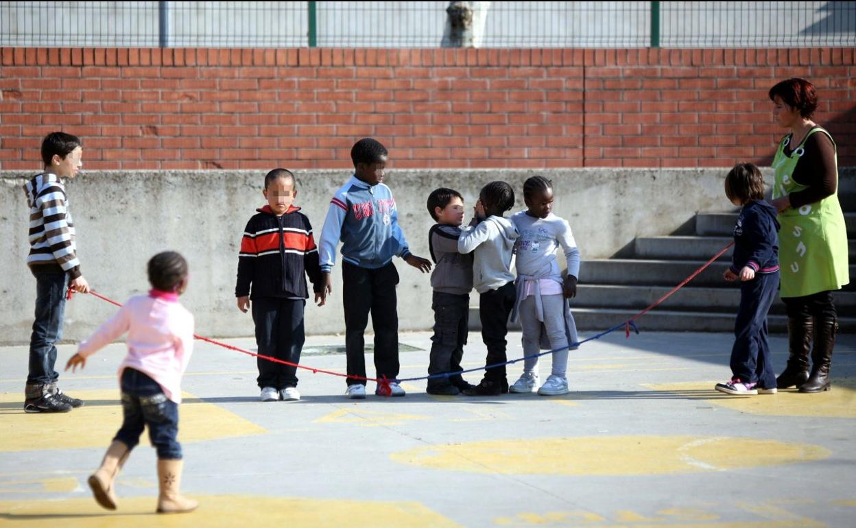 Un grupo de alumnos inmigrantes juega en el patio de un colegio. 