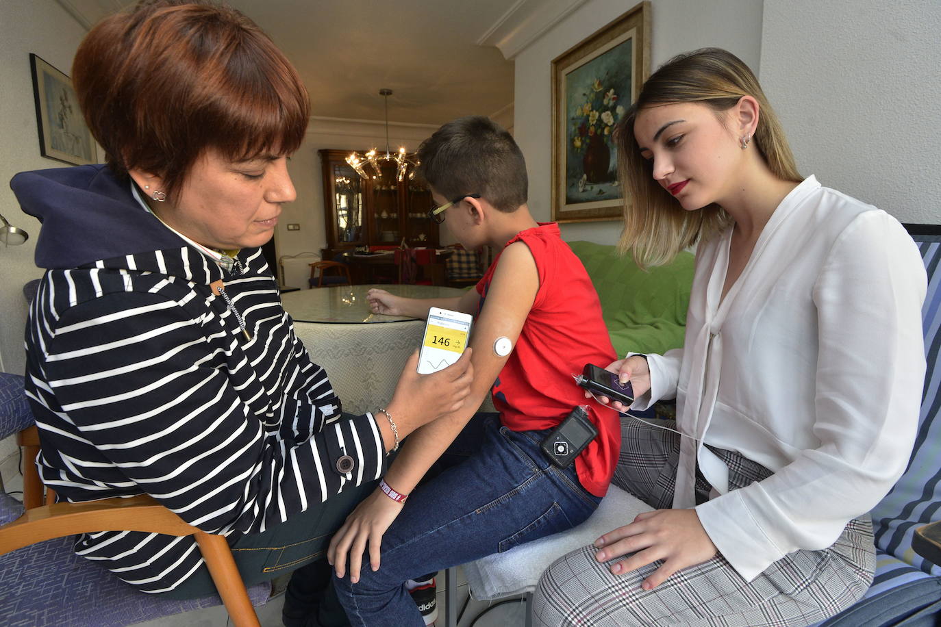 La familia de un niño con un sensor de glucosa observa los resultados. 