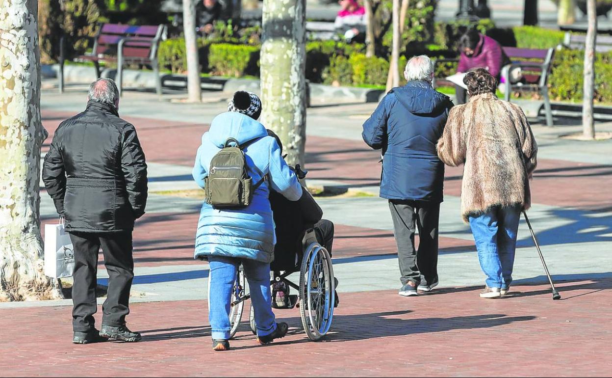 Dos personas mayores pasean por Logroño con la ayuda de su bastón. 
